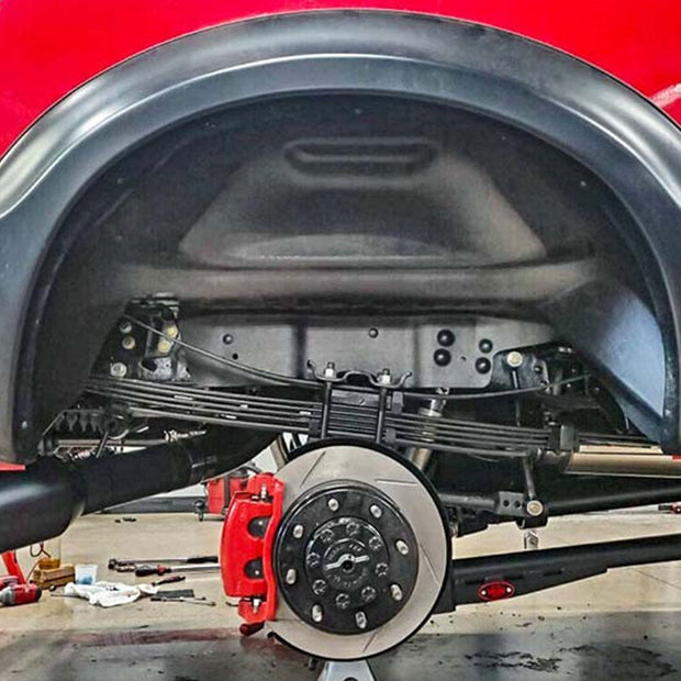 Set of an S&B Leaf Spring Shim Kit, 8 Qty 1/8" Shims installed on the running gear of a car