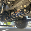 Undercarriage view of a vehicle showing the front suspension of an  SB Fully Loaded Kit For 2011-2016 F450  and steering system components.