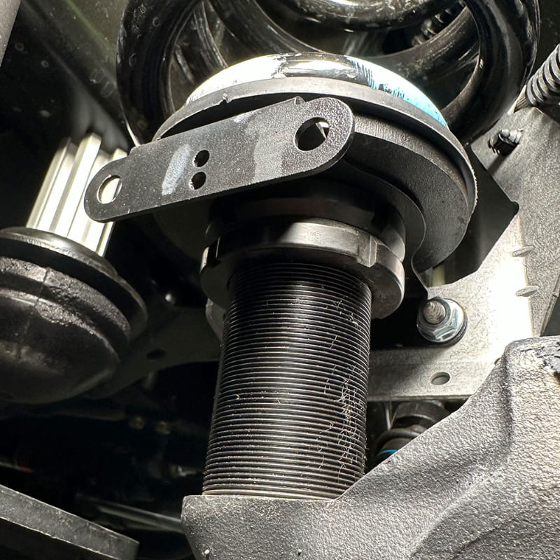 Close up Undercarriage view of a vehicle showing the front suspension of an  SB Fully Loaded Kit For 2011-2016 F450  and steering system components.