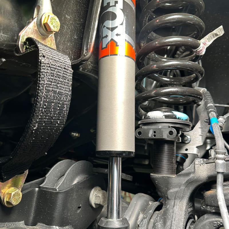 Close-up of vehicle suspension system with tools on a clear day