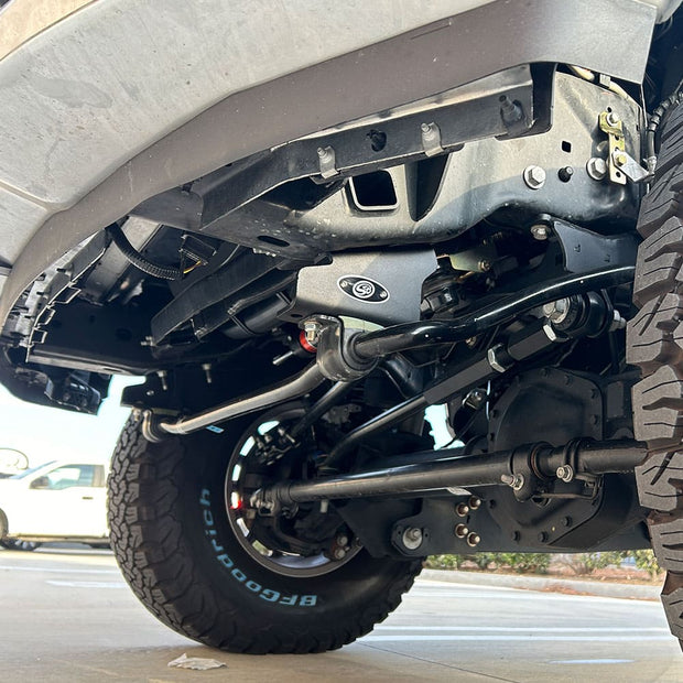 Undercarriage of a vehicle showing a sway bar system, brackets, and end links.