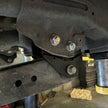 Close-up of a vehicle suspension system with bolts and metal components.