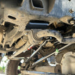 Close-up of a vehicle's suspension system with visible rust and wear.