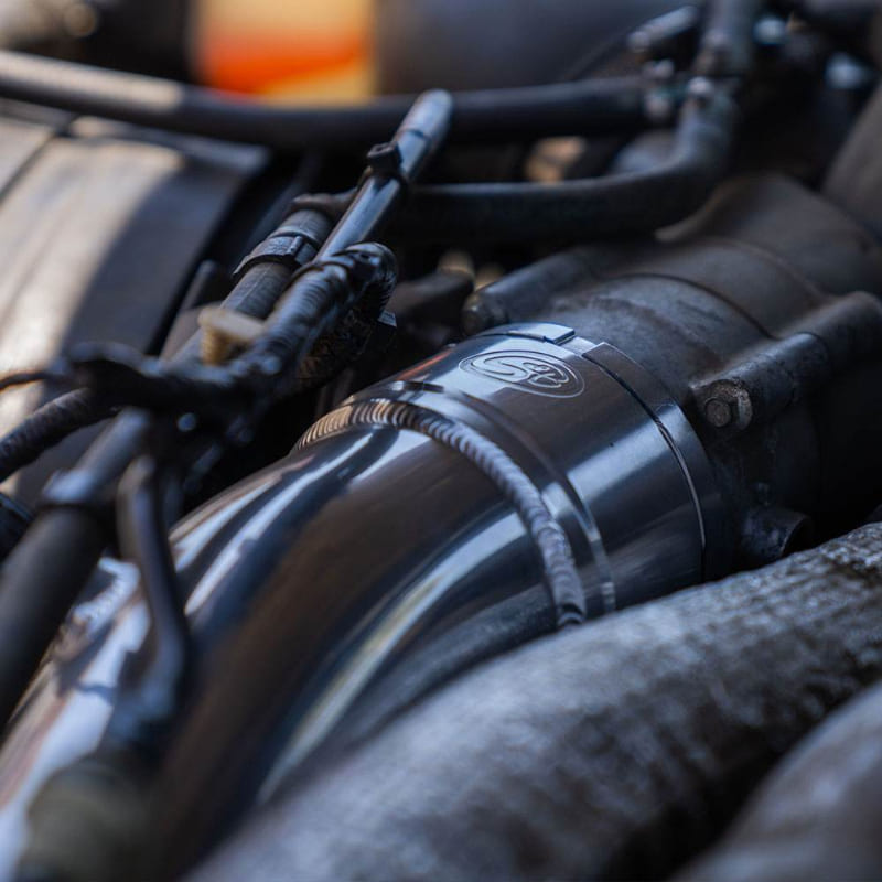 Close-up of an S&B Filters Cold Side Intercooler Pipe for 2023-2025 Ford Powerstroke F-450 / F-550 6.7L installed in a car