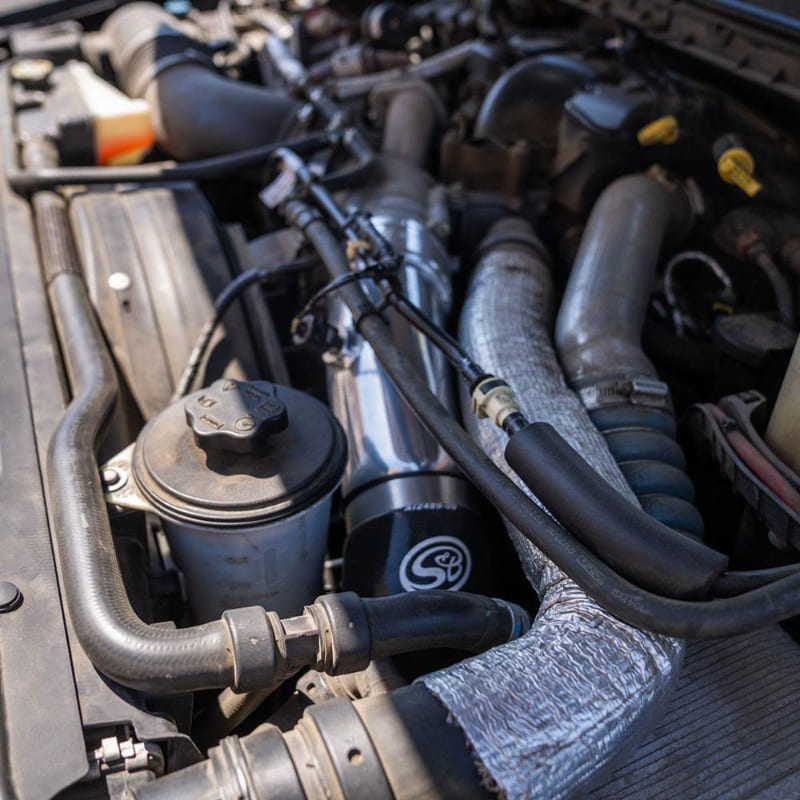 Close-up of an S&B Filters Cold Side Intercooler Pipe for 2023-2025 Ford Powerstroke F-450 / F-550 6.7L installed in a car