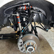 Undercarriage view of a vehicle showing the front suspension of an  SB Fully Loaded Kit For 2011-2016 F450  and steering system components.
