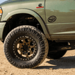 A green truck with a decal of S&B logo on the fender.