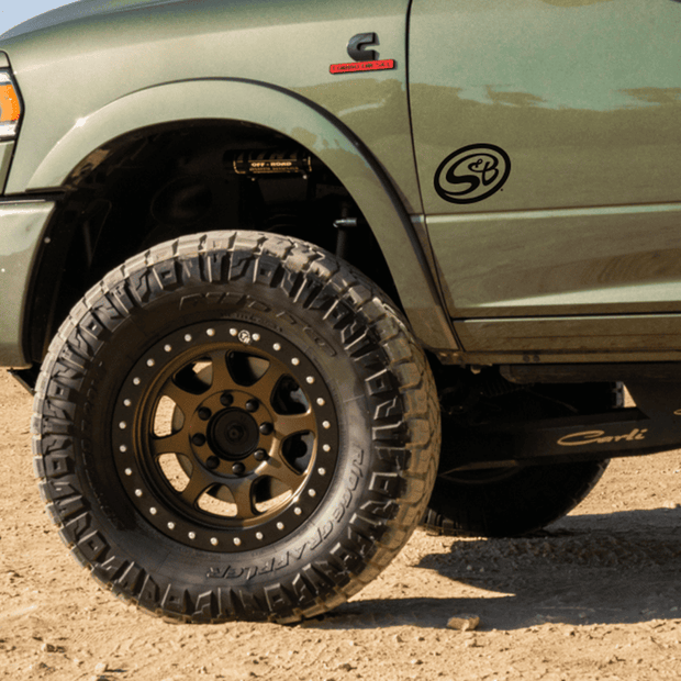 A green truck with a decal of S&B logo on the fender.
